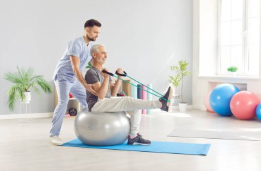 Doctor or nurse assists a senior, elderly patient with stretching exercises during a rehabilitation session. Physical therapy promotes recovery through sport based movements and healthcare support.