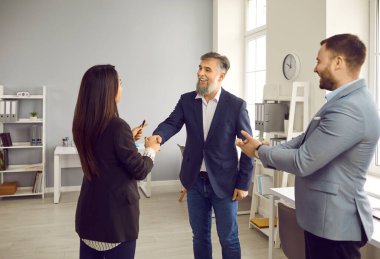 Ofiste duran ve anlaşmaya sevinen üç genç iş adamından oluşan bir grup greve gitti. Erkek kadınla tokalaşırken toplantıyı bitirir, kontrat imzalar ya da yeni çalışanı selamlar..