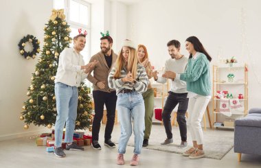 Happy overjoyed friends party fun dance, Happy New Year, Merry Christmas celebration dancing celebrating eve together, excited diverse people enjoying celebration at home near tree, smiling, laughing