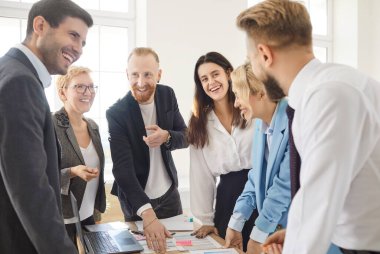Happy group of business people and company employees in formal clothes discussing job projects talking in office making great decisions with brainstorming. Coworkers working together at workplace