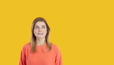 Nervous but curious woman looking up at copyspace background on right side. Worried girl thinking about something unpleasant, envying, feeling jealous, confused, puzzled, unsure, embarrassed, ashamed