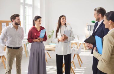 Bir grup mutlu, gülümseyen iş adamının portresi toplantının ardından çember oluşturarak sohbet ediyorlar. Şirket çalışanları ya da modern ofiste konuşan personel grubu ya da iş projesini tartışan konferans