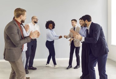 Bir grup mutlu iş adamı. Genç erkekler ve kadınlar ofiste eğleniyorlar. İyi bir anlaşma yaptıkları için mutlular. Şirket çalışanları, kadın meslektaşlarının başarısını kutluyor..