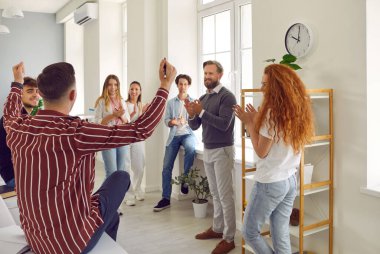 Bir grup mutlu okul, üniversite ya da üniversite öğrencisinin yanı sıra öğretmen, öğrenci yarışmasındaki zaferini kutluyor, başarıyı kutluyor, gülümsüyor, alkışlıyor ve eğleniyor.