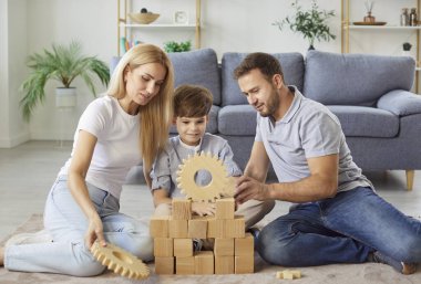Olumlu ebeveynler ve oğullar neşeli anlar yaşarlar ve tahta oyuncaklarla oynarlar, evde kaliteli zaman geçirmenin tadını çıkarırlar. Mutluluk, çocukluk anıları ve ailecek geçirdiğimiz boş zamanlar..