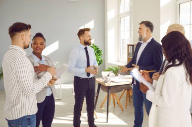 Muhtelif iş adamları ya da şirket çalışanları ofiste toplanırken konuşuyorlar. İş arkadaşları yeni bir proje ya da girişim hakkında konuşan meslektaşlarını dinliyor, şirketi analiz ediyorlar. Takım çalışması konsepti.
