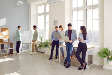 Bir grup genç iş adamı ofiste çalışıyor ve iletişim kuruyor. Çok ırklı çeşitli meslektaşlar beyin fırtınası yapıyorlar, dizüstü bilgisayar kullanıyorlar, iş projelerini tartışıyorlar. Takım çalışması, işbirliği, ortaklık