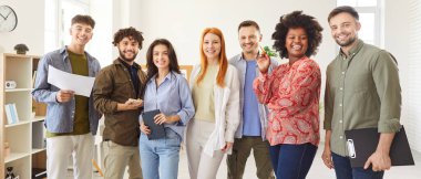 Çok ırklı, mutlu, gündelik giysiler içinde bir arada durup gülümseyen ve kameraya bakan genç insanlardan oluşan bir grup. Mutlu arkadaşlar, öğrenciler ya da meslektaşlardan oluşan bir ekip sırada duruyor, ofiste poz veriyorlar. Pankart