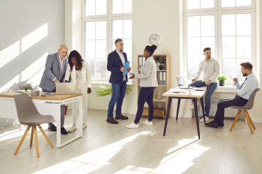 Bir grup iş adamının toplantıdan sonra konuştuğu uzun bir fotoğraf. Şirket çalışanları ekibi ya da grup çalışanları, ara sırasında ofiste birbirleriyle konuşuyorlar..