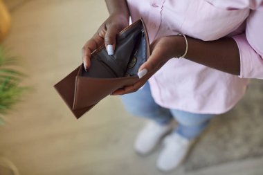 Cüzdanı boş, bulanık, tanınmayan Afro-Amerikan kadın. Kız cüzdanı parasız açtı. Konsept boş kahverengi cüzdan, finans ve ekonomi, para yok, borç, yoksulluk