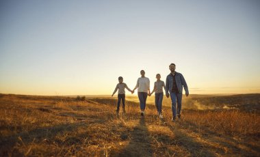 Dört çocuklu mutlu bir aile, pilot gözlüklü iki çocuk ve gün batımında birlikte el ele yürüyüp eğlenen bir kız. Aile eğlencesi açık hava konsepti