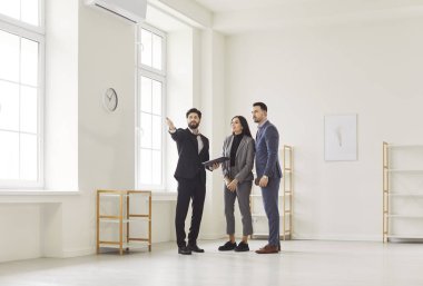 İzleme sırasında genç bir çifte boş bir daire gösteren emlakçı özelliklerini ve düzenini belirterek kira şartlarını tartışıyor. Erkek emlakçı, genç erkek ve kadına yeni bir ev gösterdi..