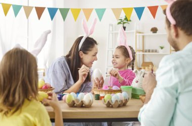 Paskalya için aile dekorasyonu, bahar tatili geleneği için renk yumurtası süslemeleri tavşan kulaklı çocuklarla eğlenceli aktiviteler, tatil için ev dekorasyonu, festival atmosferi.