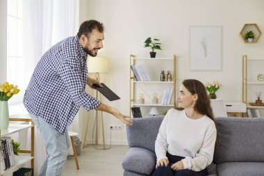 Evdeki kavgada bağırarak tartışan adam. Koca, şüpheye, ihanete ve gizli sohbete atıfta bulunarak kıskançlık ve güveni gözler önüne sererek tabletle yüzleşir. İhanet, evlilik sorunları, ilişkiler konsepti