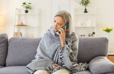 Hasta, soğuk algınlığı ya da grip olan yaşlı bir kadın evden arandığı sırada telefonla iletişim kuruyor. Hasta görünüyor, ateş ve virüsle ilgili rahatsızlık belirtileri gösteriyor..