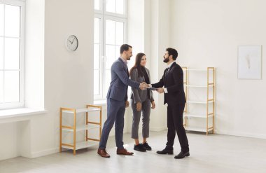 Emlakçıyla müvekkil arasındaki el sıkışma, satış sözleşmesi imzalama ve emlak, kira sözleşmesi. İş adamları kiralamak ya da satın almak için yeni ofise giderler. Ortaklık kavramı