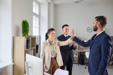 Takım çalışması başarısı iş dünyası ekibi ofiste beşlik çaktı. Meslektaşlar bir toplantının ardından kutlama yaparlar, bir çalışma alanında işbirliği, strateji ve analizlerin altını çizerler. Güçlü takım çalışması başarı kavramı.