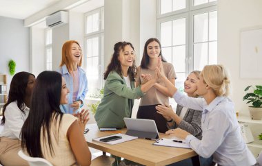 Kadınlar ofis masasında buluştuklarında beşlik çakar. Antrenman sırasında çeşitli grup planlama stratejileriniz kutlu olsun, meslektaşlarınız takım çalışması başarısını ve işbirliğini alkışladı, başarılı takım oluşturma