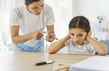 Anne ve kızı evde okul ödevleri hakkında tartışıyorlar. Kadın ebeveyn şikayette bulunup, stres ve disiplin uygularken, kız çocuğu sorunlarla karşı karşıya kalıyor. Ebeveynlik ve aile çatışması.