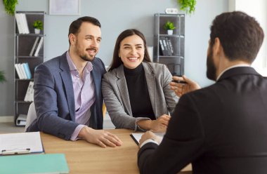 Temsilci ve birkaç müşteri, iş adamları oturuyor, konuşuyor, tartışıyor, el kol hareketi yapıyor, gülümsüyor, ofiste başarılı bir iş görüşmesinde olumlu etkileşimde bulunuyor, keyifli profesyonel konsültasyon