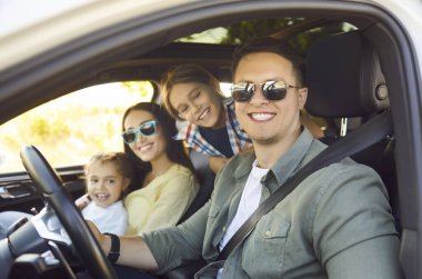 Mutlu aile yolculukları arabayla, insanlar yaz yolculuklarında güvendeler. Ebeveynler ve çocuklar güvenle ata biniyor, tatilin ve gün ışığının tadını çıkarıyorlar. İçlerinde oturan anne ve baba ve kardeşlerle birlikte araç kullanıyorlar.