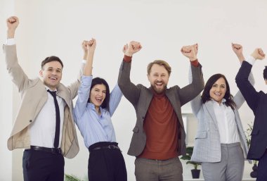 İş hayatında başarıyı kutlayan takım elbiseli bir grup iş adamının portresi ya da stüdyonun gri arka planında izole edilmiş kazananlar gibi el hareketleriyle bir anlaşma yapmak. Takım çalışması konsepti