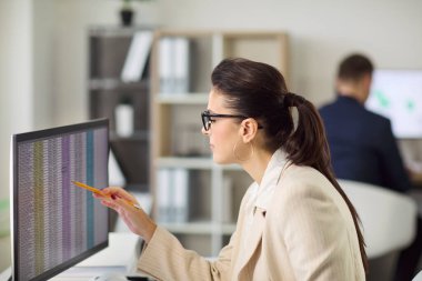 Bilgisayar ofisindeki muhasebeci denetim veri analizi. Odaklanmış iş kadını, doğru mali raporlar için hesap tablolarını gözden geçiriyor. Parlak, açık modern ofis. Açık doğruluk ve güven kavramı.