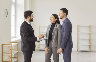 Genç ve mutlu bir çift, erkek emlakçı ile anlaşmaya varıyor. Yeni, modern, boş dairelerde duran bir sözleşmeyi tartışıyorlar. Gayrimenkul ve emlak kavramı.