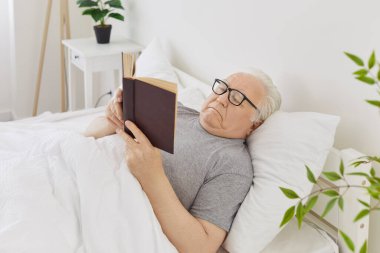 Gözlüklü yaşlı ve gri saçlı bir adamın portresi. Evdeki yatak odasında uzanmış kitap okuyor. Emekli, kendine güvenen ve hafta sonları edebiyatla eğlenen biri..