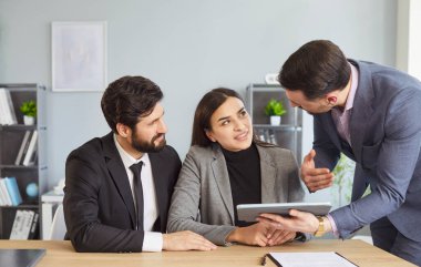 Mutlu iş ortaklarının grup portresi modern ofiste, başarılı çalışanlar çalışma alanında buluşmayı planlıyorlar, kameralara bakıp gülümsüyorlar, takım çalışmasından zevk alıyorlar, işbirliği yapıyorlar.