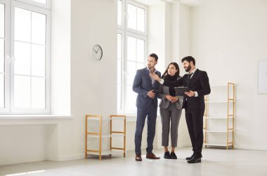 Menajer, mimar ya da iç mimar toplantıda çiftlere yeni daire planı gösteriyor, emlakçı danışmanlığı yapan müşteriler emlak teklifi yapıyor, mortgage kredisi yatırımı, ofis onarım planı