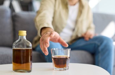 Alkol bağımlısı bir adam, şişe ve bardak. Kanepede içiyor, taciz problemine kayıyor alkolizm ve bağımlılık, derin depresyon ve anksiyete. Alkol hakkında açık bir uyarı.