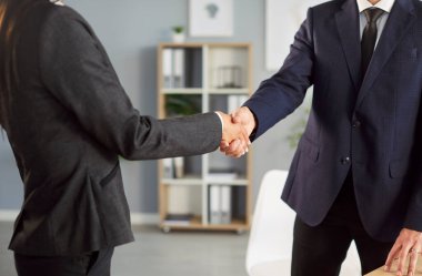 Kırpılmış iki iş adamı ve kadın başarılı bir toplantıdan sonra ofiste tokalaşırken vuruldu. İki profesyonel el sıkışma, ortaklık anlaşması, iş birleşme ve satın alma..