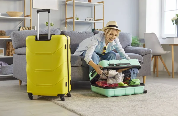Yaz tatiline hazır bir kadın evde mutlu bir bavul, iki valiz, planlama, seyahat ya da eğlence için hazırlık, keyif alma ya da deniz gevşeme hayali, tatil gezisi.