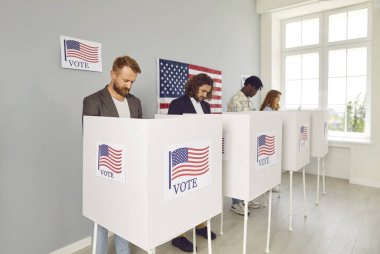 ABD başkanlık seçimlerinde oy kullanan çeşitli Amerikan vatandaşları. Çok sayıda insan seçim yapıyor ve ABD bayraklı kabinlerdeki farklı adaylara oy veriyor. Demokrasi kavramı