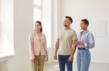 Emlakçı, emlakçı, genç çifti sunmaktan mutluluk duyar modern kapalı alan, profesyonel danışma, satmadan önce odaklanmış ve meşgul tartışma, ev kiralama, yeni aile sahipleri için bina