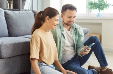 30 'lu yaşlardaki çekici çift modern akıllı telefonlarıyla yerde oturuyor ve hafta sonları internette vakit geçiriyorlar. Dijital bağlantının, iletişimin, modern teknoloji kullanımının günlük keyfi