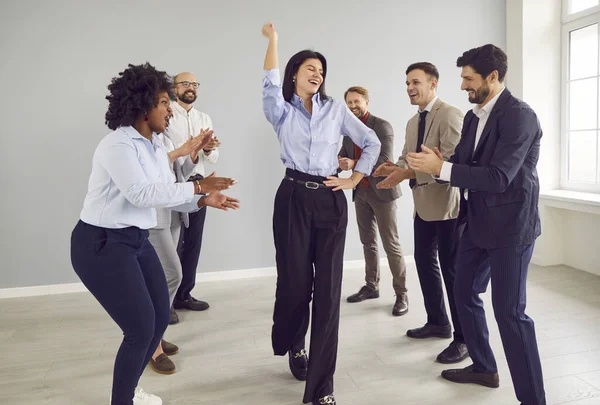 Bir grup mutlu iş adamı. Genç erkekler ve kadınlar ofiste eğleniyorlar. İyi bir anlaşma yaptıkları için mutlular. Şirket çalışanları, kadın meslektaşlarının başarısını kutluyor..