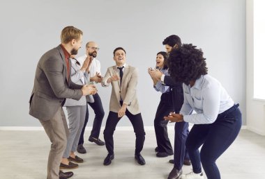 Mutlu bir şirket çalışanı takım elbise giyer ve boş ofiste dans eder, başarıyı kutlar, iş arkadaşlarıyla anlaşma ya da iş başarısı yapar ve meslektaşlarını alkışlar..