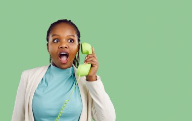 Sersemlemiş genç Afrikalı Amerikalı kadın ev telefonundan şok edici haberler alıyor. Şaşkın siyah kız telli telefondan aradı. Teklif ya da satış anlaşmasına şaşırdı ve şaşırdı. Stüdyo arkaplanı.