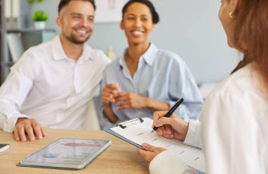 Karısı hamile kalmayı planlarken klinikte oturan mutlu genç adam. Çeşitli çiftler hastanede aile doktoru terapistiyle görüşüyor. Sağlık ve Tıp Konsepti.