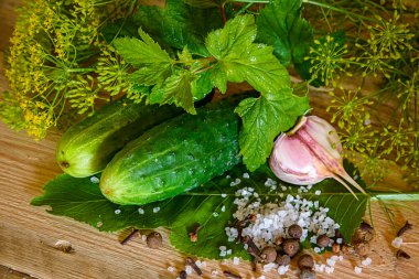 Ripe cucumbers with spices for pickling on a wooden rustic table clipart