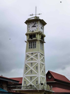 Alacakaranlık, tarihi kent meydanındaki saat kulesini aydınlatıyor. Mimari harikalar, şehir zarafetiyle, dramatik gökyüzü, zamansız güzellik.