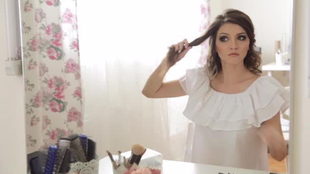 Woman making hairdo looking in mirror — Stock Video