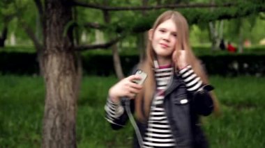 Pretty genç kız parkta kulaklık müzik dinleme