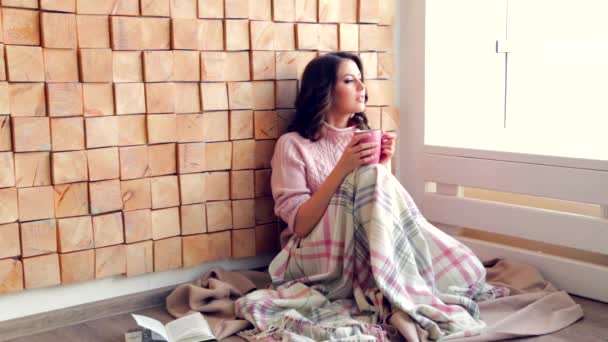 Beautiful woman drinking coffee or tea looking at the window at home — Stock Video