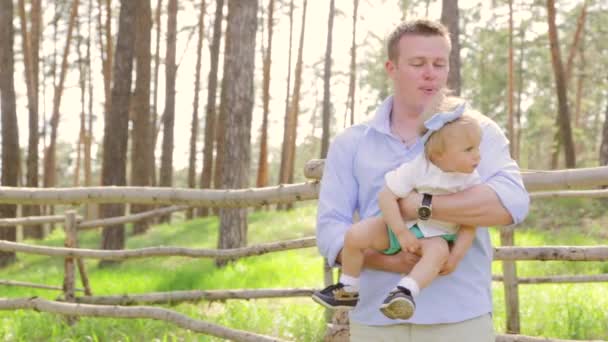 Dad holding kissing his sweet daughter baby with a bow on her head, baby laughs — Stock Video