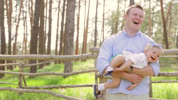 Ο μπαμπάς που κατέχουν το μωρό γλυκιά του κόρη του με ένα τόξο στο κεφάλι της, παιδικά γέλια — Αρχείο Βίντεο