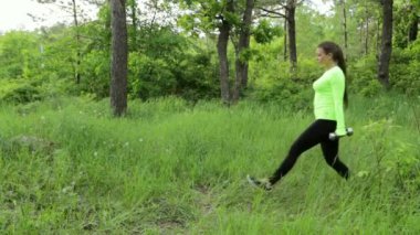 Genç kadın egzersiz yapıyor crouch dumbbels Park ile