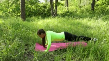 Genç kadının egzersiz yukarı itin mat park yapması